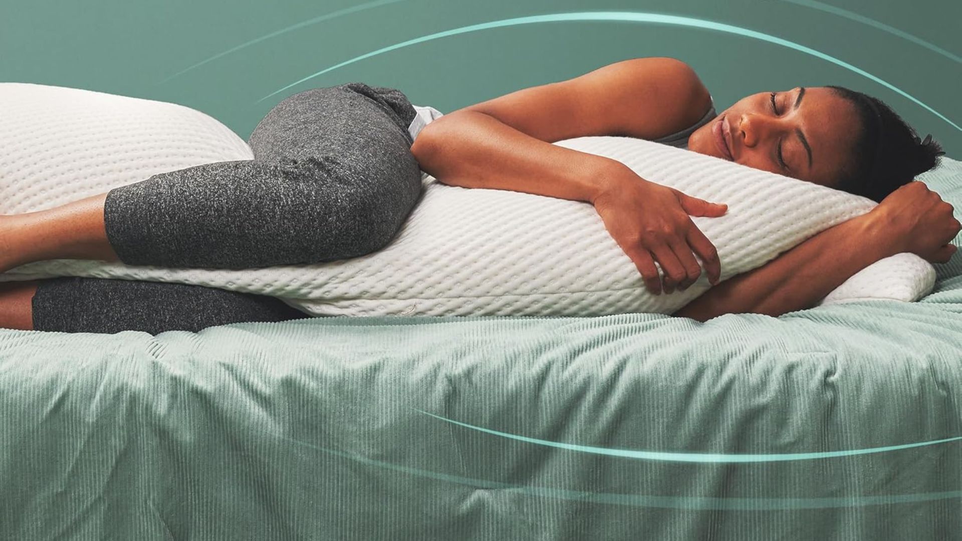 A woman lying on her side cuddling a white Snugge-pedic Body Pillow
