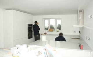 kitchen units being fitted during process of building a house