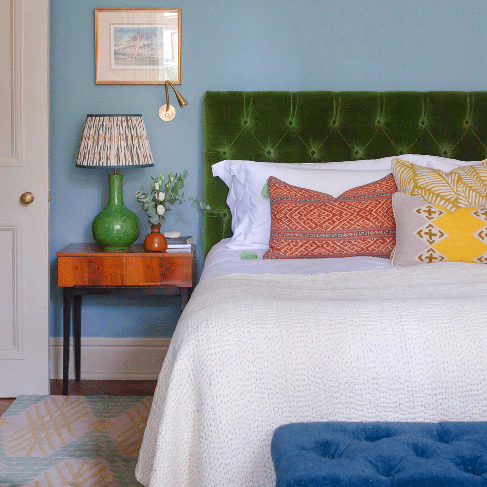 bedroom with bedside table and blue wall