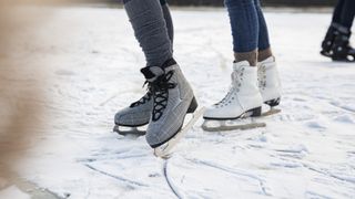 Feet of ice skating people on frozen lake