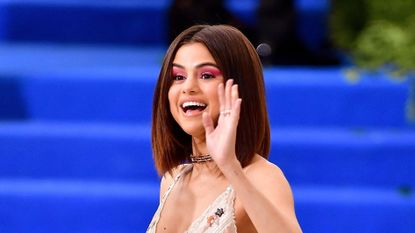 Selena Gomez waving enthusiastically.