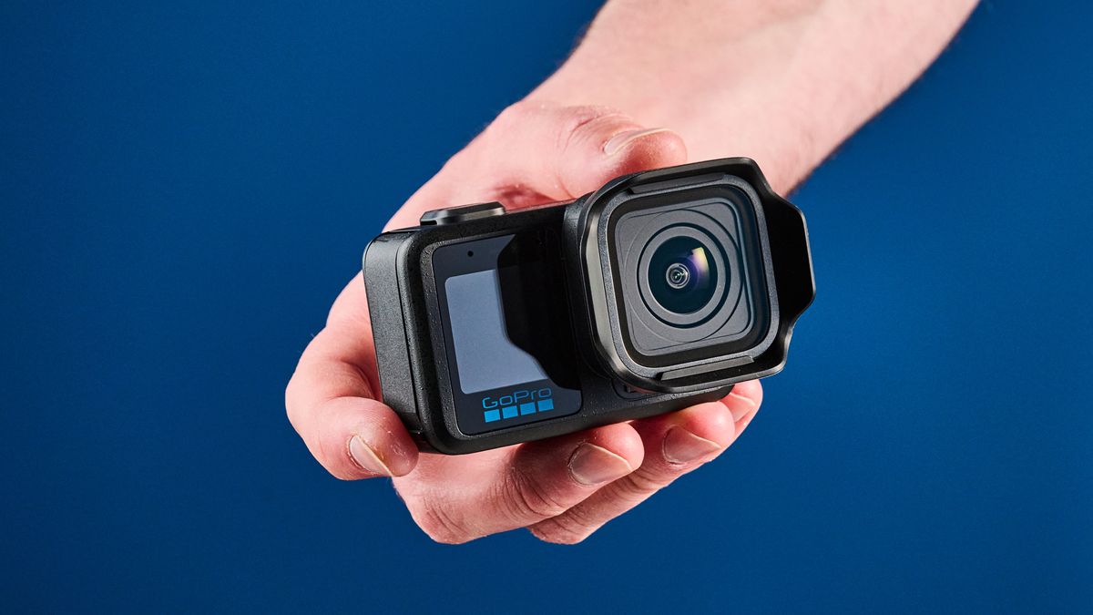 The GoPro Mission 1 Pro in hand, against a blue background