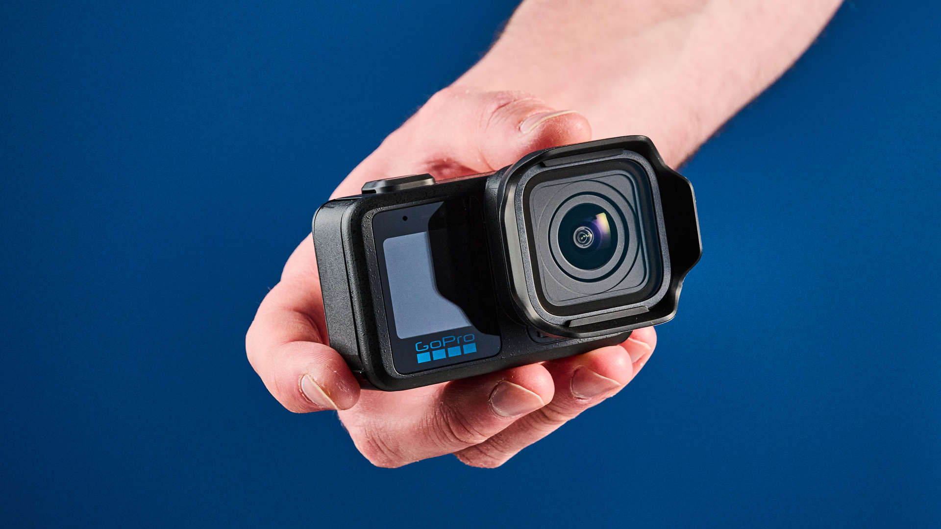 The GoPro Mission 1 Pro in hand, against a blue background