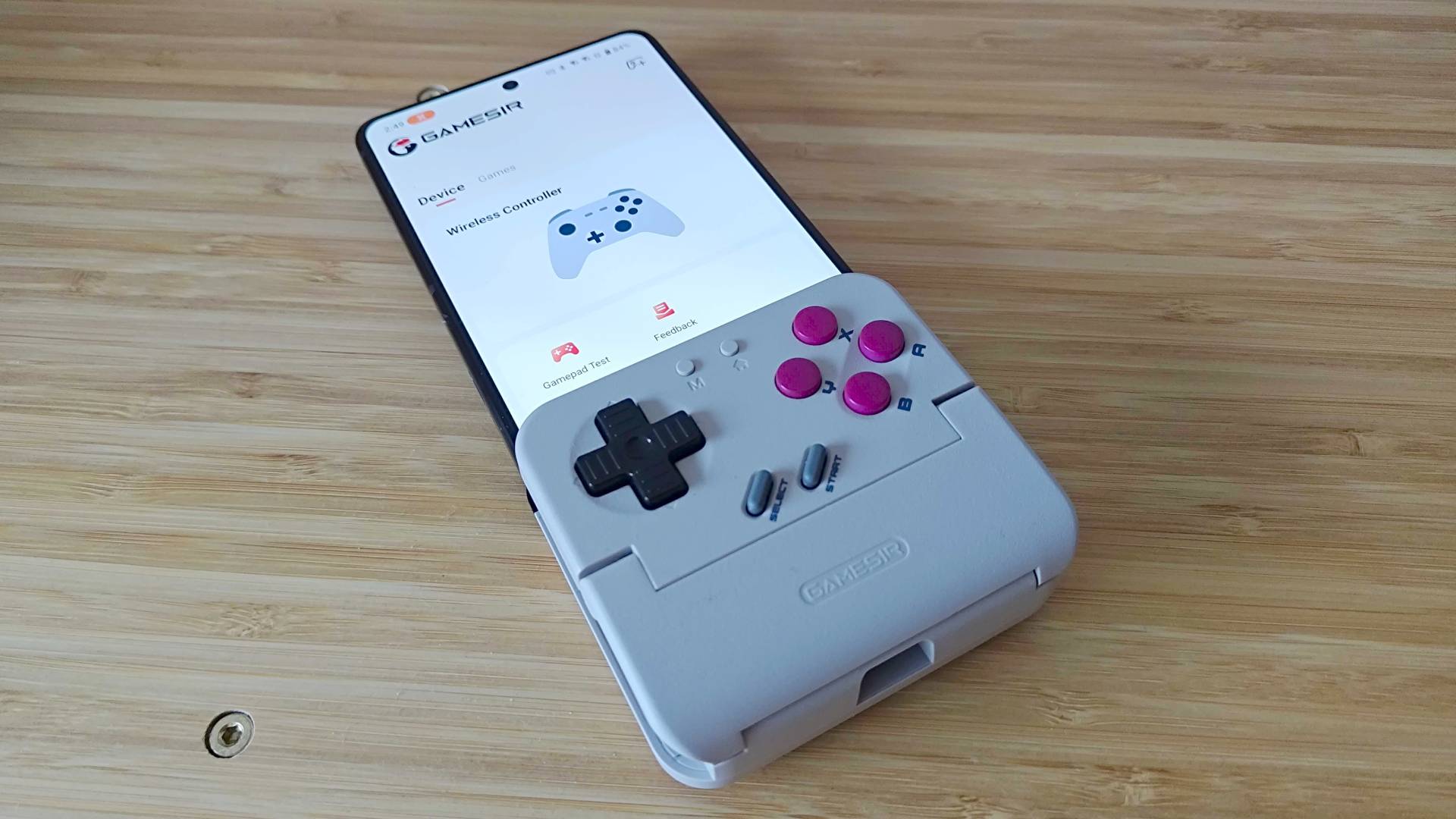 Gamesir Pocket Taco on woodgrain unit connected to Asus ROG Phone 9 Pro with the app on screen.