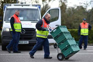 A shop worker moves trays used in the click and collect service at a Tesco supermarket