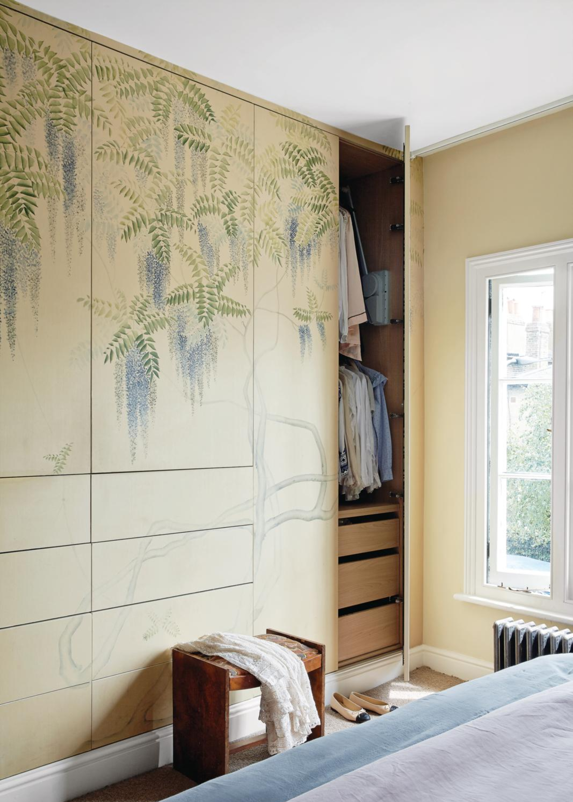 A bedroom with a wardrobe featuring a mural