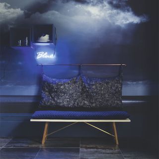 room with stormy patterned wall and blue colour seating area