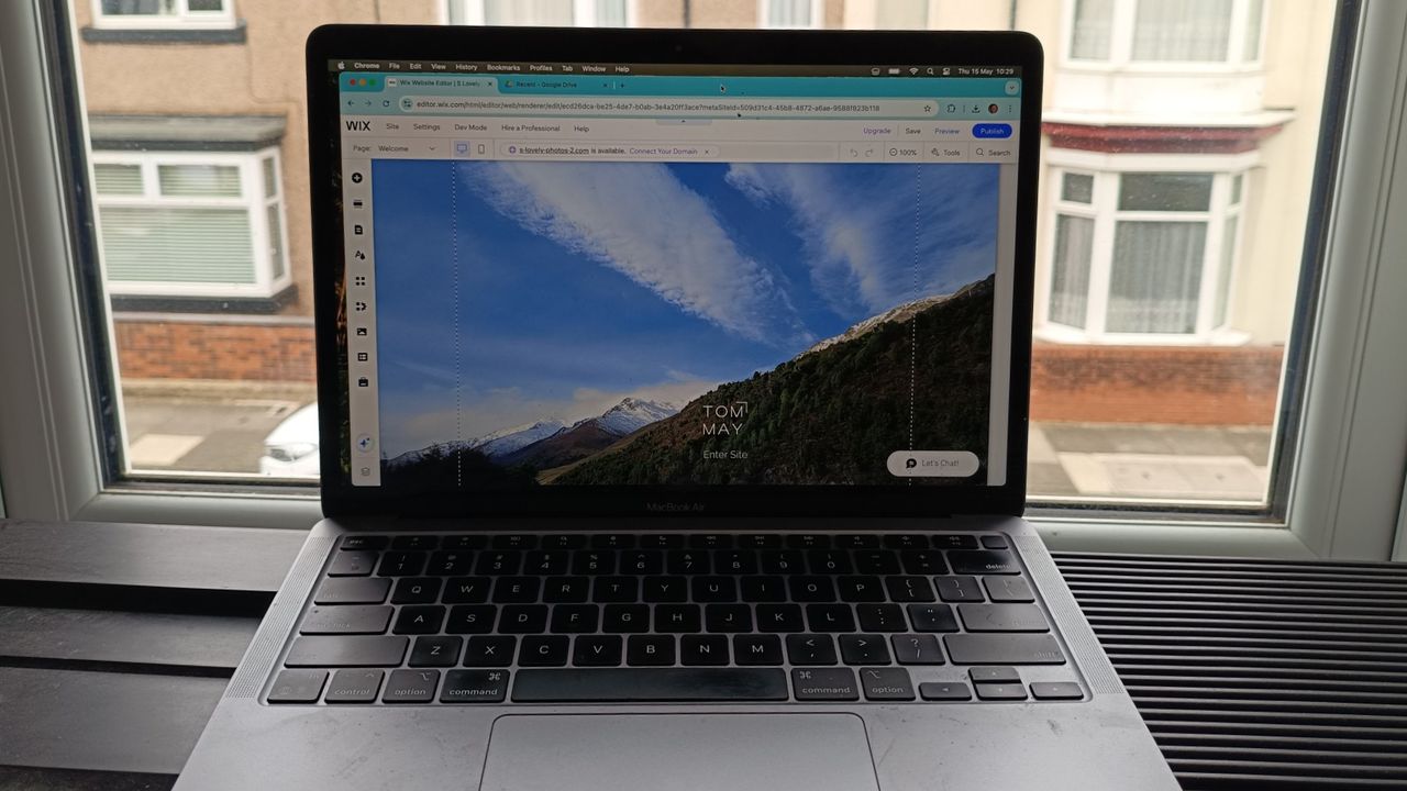 Wix website being edited on laptop in front of window overlooking a terraced street