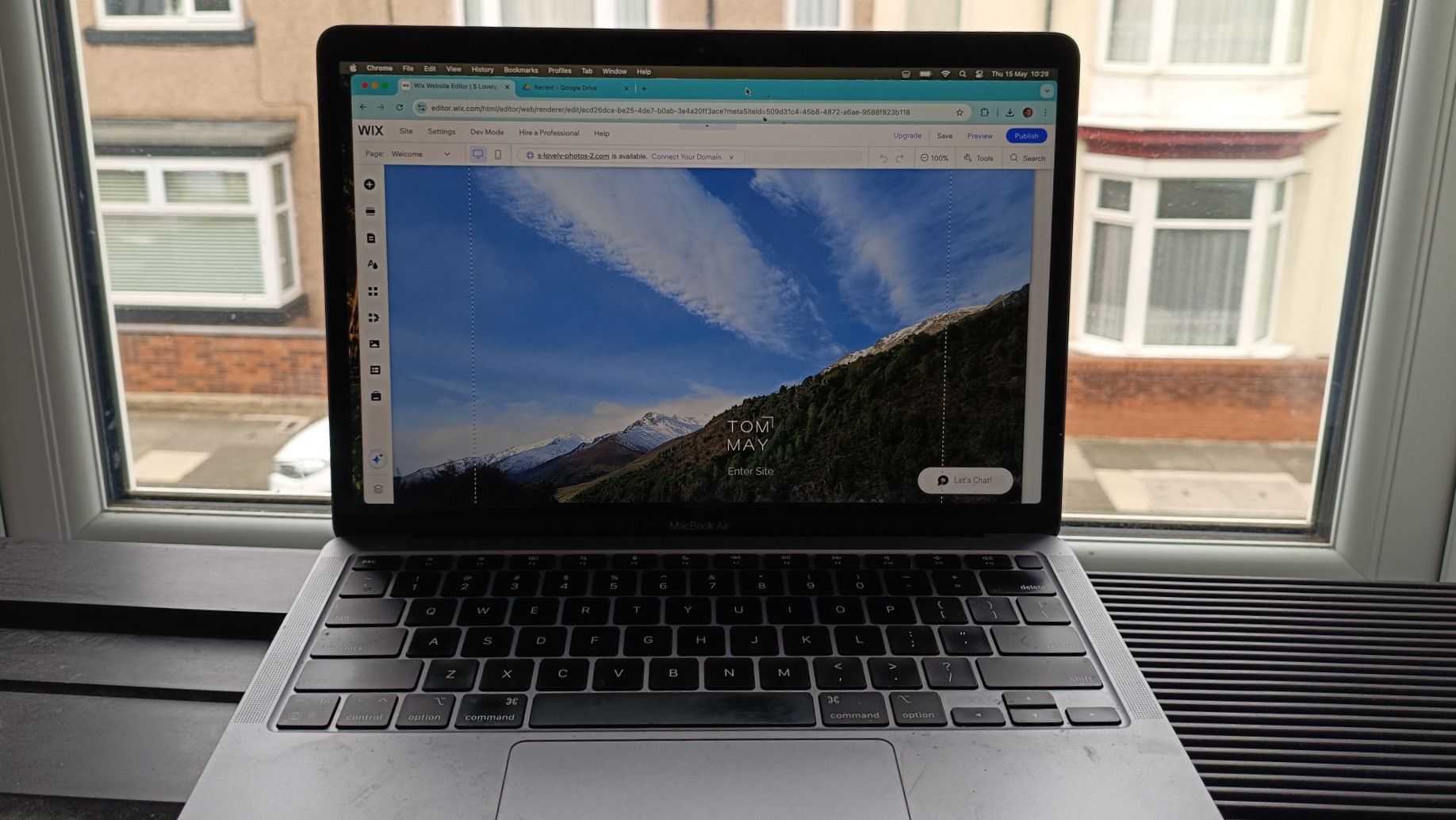 Wix website being edited on laptop in front of window overlooking a terraced street