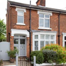 Red brick semi-detached house front exterior with duck egg blue painted front door