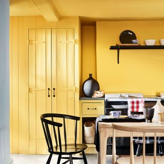 kitchen with yellow coloured and wooden table and chair