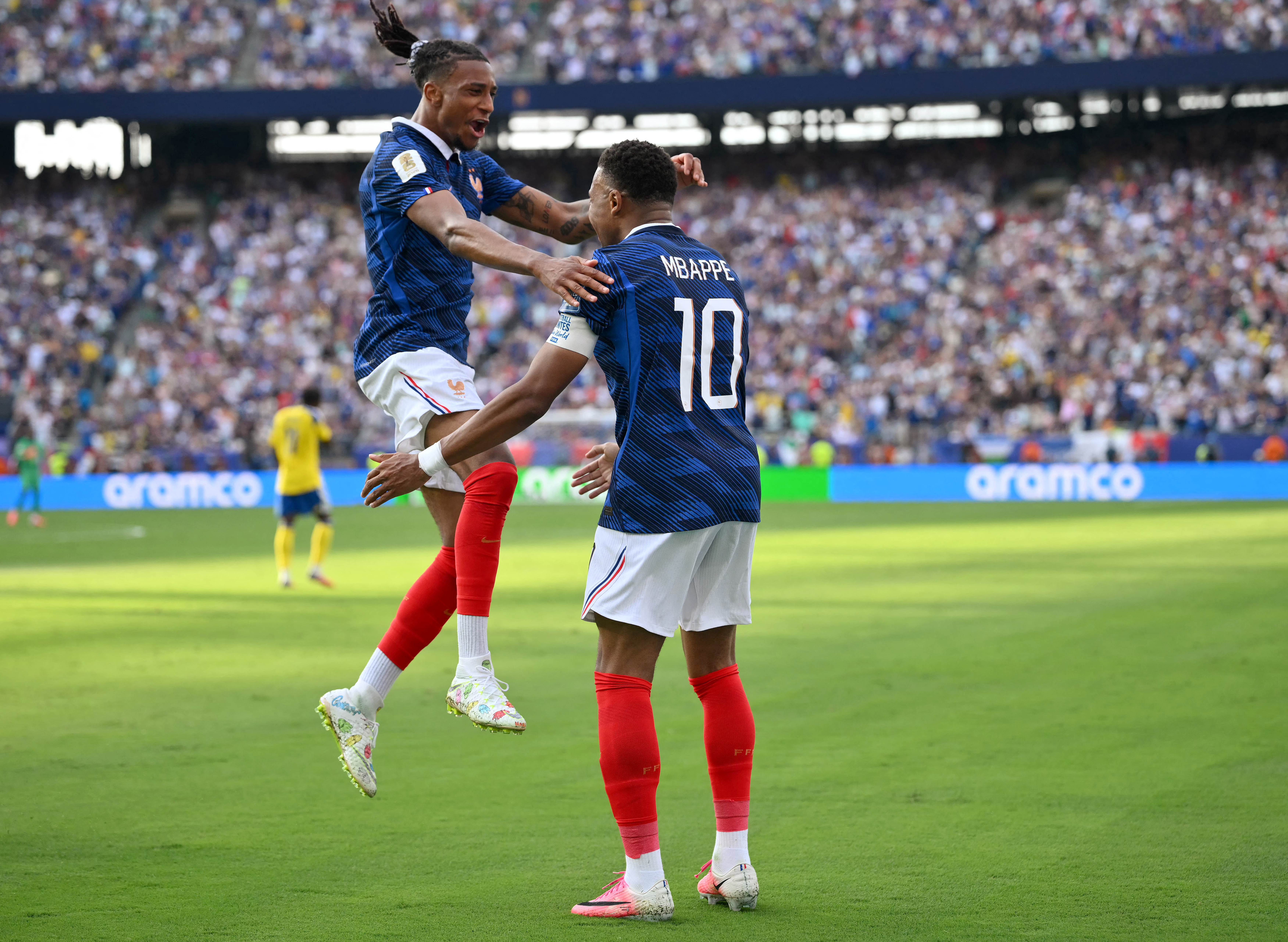 Kylian Mbappe celebrates scoring his team's third goal against Sweden with Michael Olise