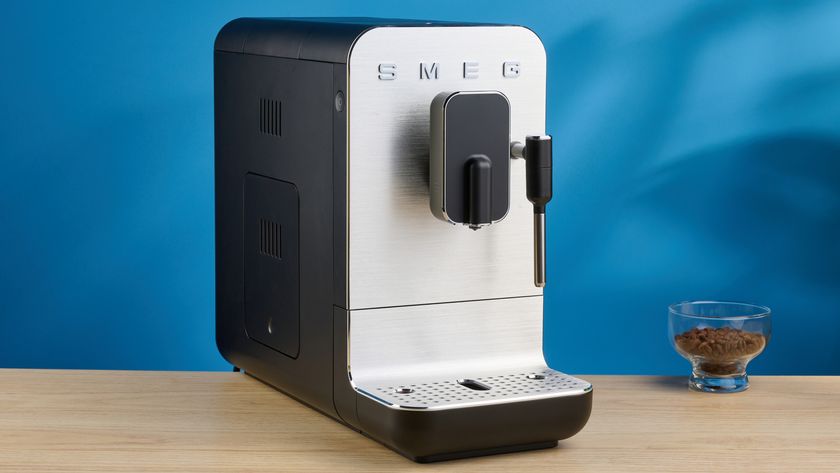 the smeg bcc12 automatic coffee machine in black showing its manual steam wand and automatic buttons and built in grinder