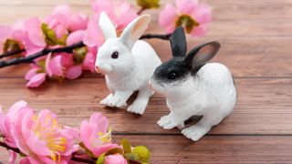 Chinese New Year 2023: Chinese New Year Of The Rabbit, stock photo of two rabbit figurines and some cherry blossom branches.