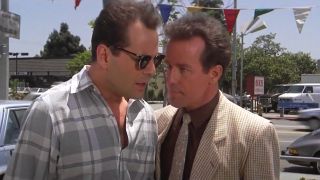 Bruce Willis and Phil Harttman have a side conversation on a car lot in Blind Date.