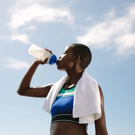 How much protein to build muscle: A woman drinking a protein shake