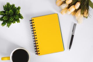 Yellow Notebook and Coffee Mug on Work Desk