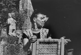 Frida Kahlo holding cigarette, Coyaocan, Mexico, 1950, by Florence Arquin