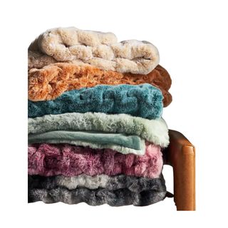 Luxe Faux Fur Throw Blanket stack of colors on a chair