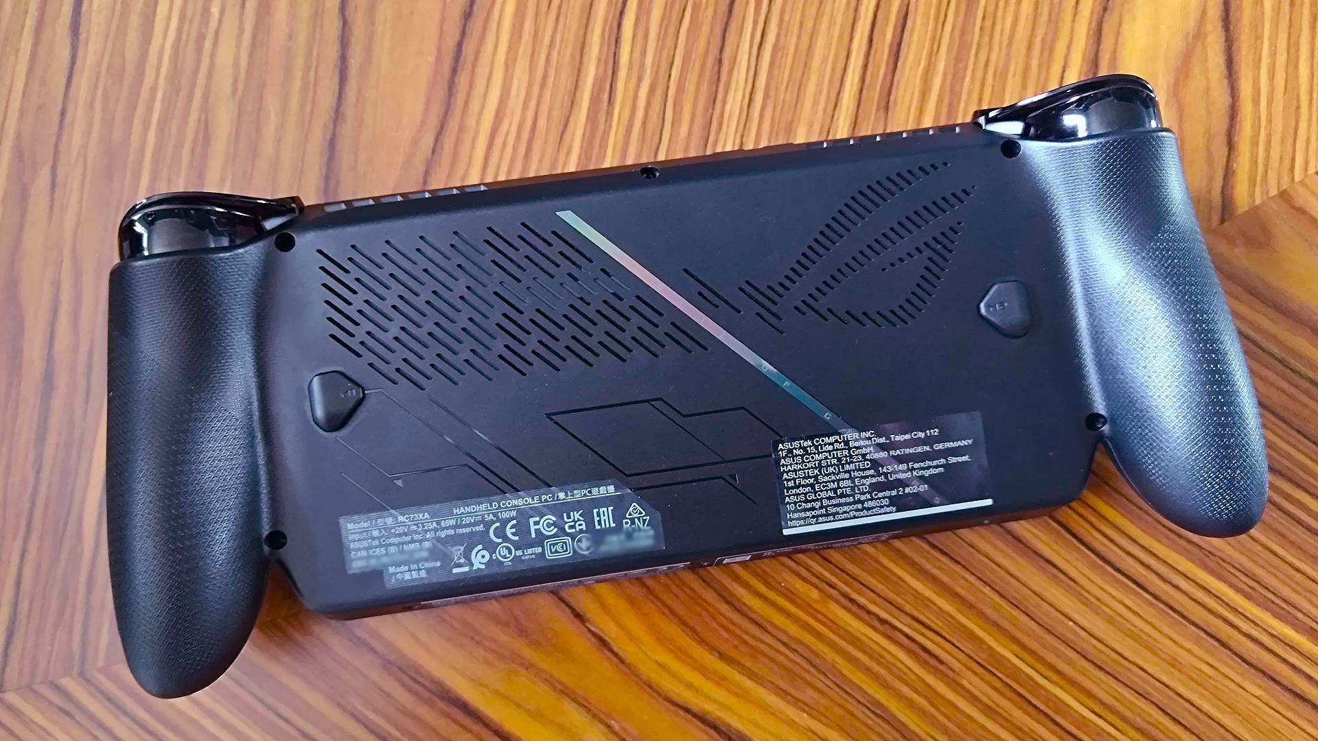 Back view of ROG Xbox Ally X on woodgrain table.