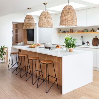 Scandi-style white kitchen with breakfast bar and large oversized pendants