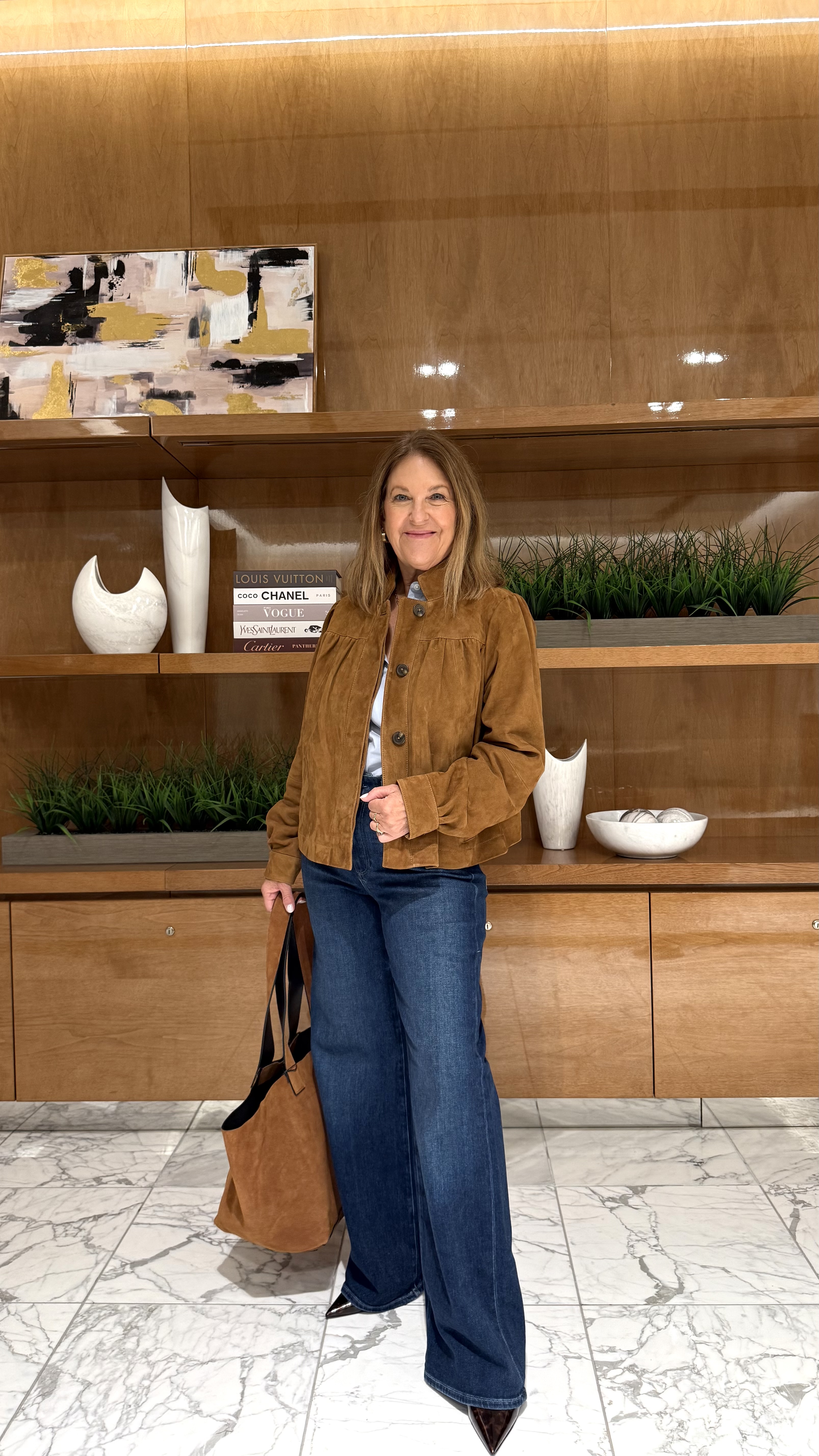 Sandy Koszarek wearing a suede jacket, a white tee, and jeans.