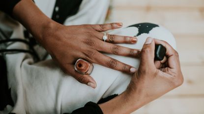 Close-up of woman painting her fingernails brown 