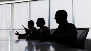Silhouettes of corporate executives in a boardroom