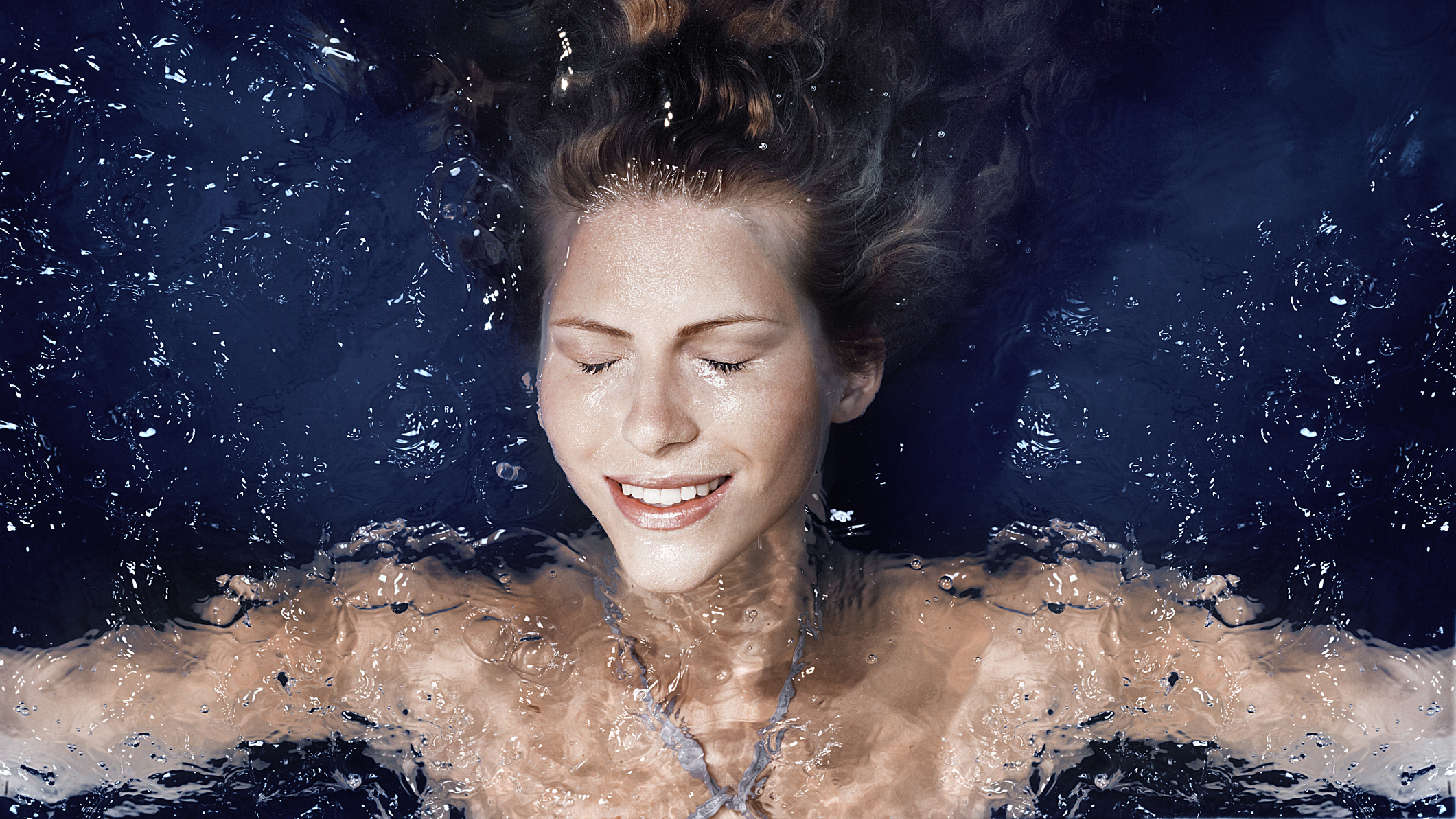 A woman relaxes in a swim spa