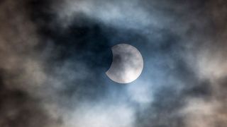 partial eclipse behind clouds