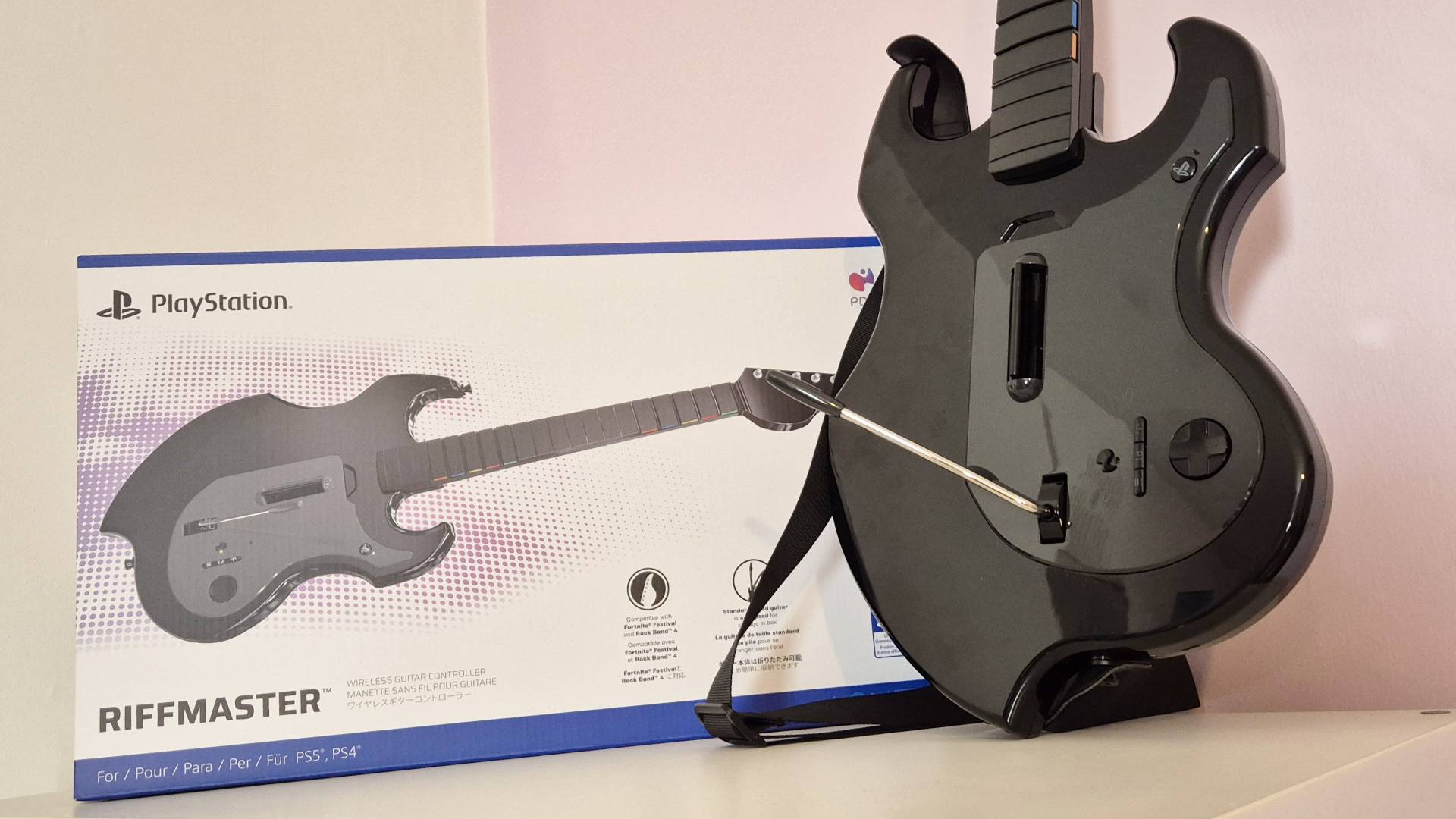 Photos of the Turtle Beach PDP Riffmaster guitar controller (PlayStation version) taken by writer Rosalie Newcombe, in a pink and white office.