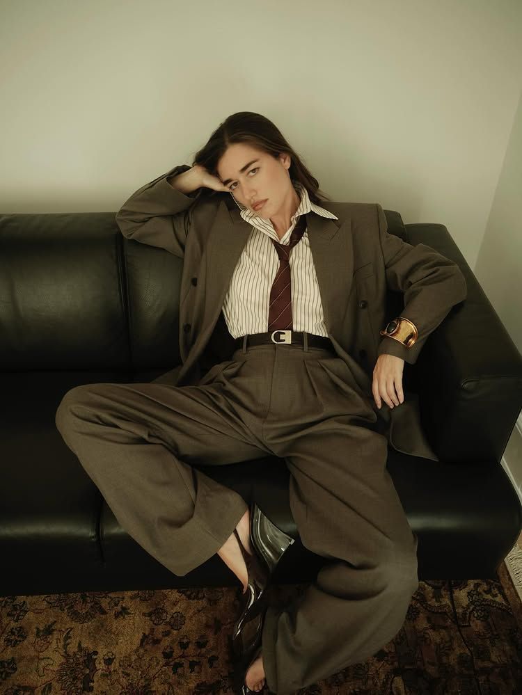 An image of @iliridakrasniqi wearing a pinstripe blouse and grey suit from Saint Laurent.