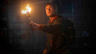 Glen Powell as Ben Richards holding a torch in The Running Man