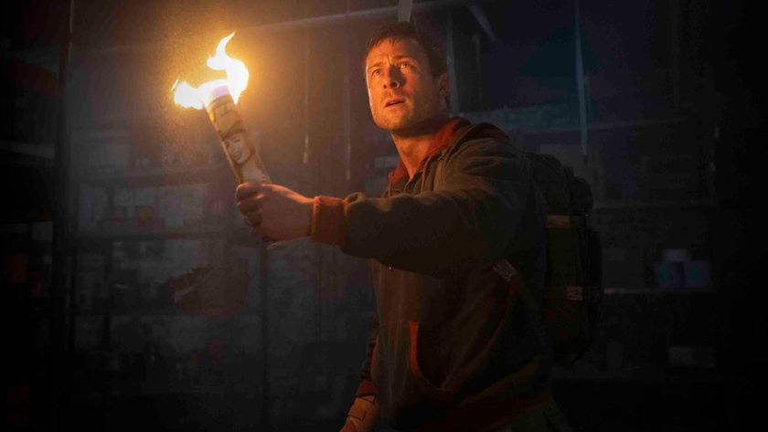 Glen Powell as Ben Richards holding a torch in The Running Man