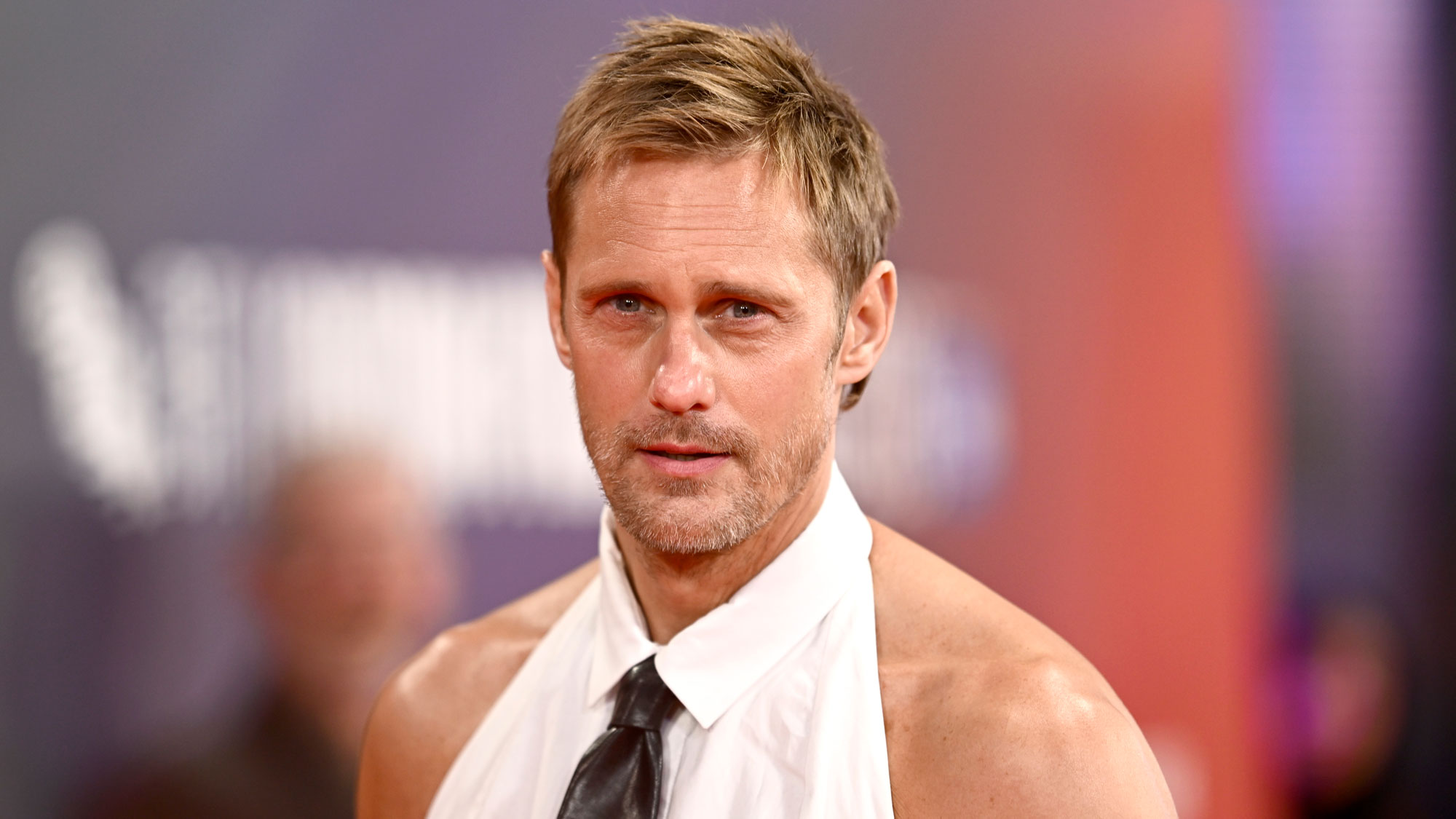 Alexander Skarsgard wears a tank top and leather pants on the red carpet promoting his film, Pillion