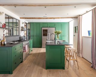 Colorful green country kitchen in 19th century Dorset barn conversion