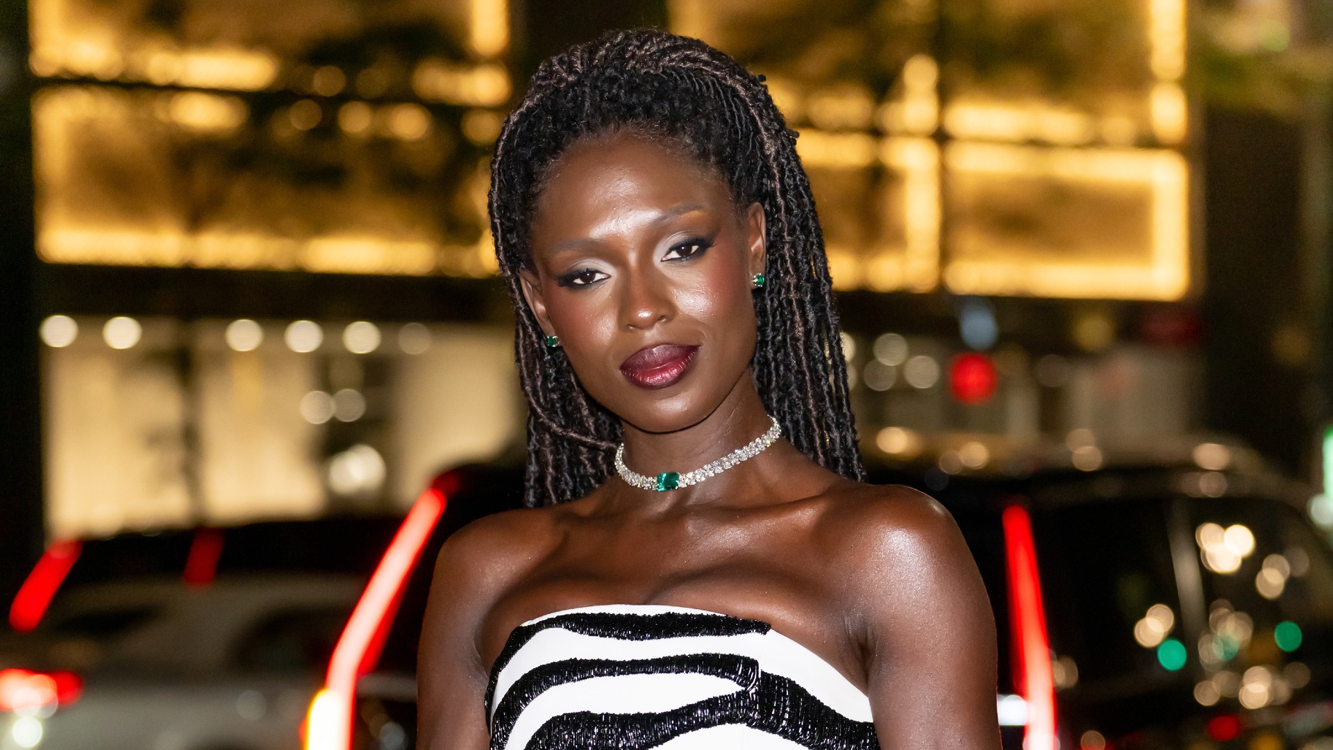 a black woman with locs wearing a zebra print, strapless dress