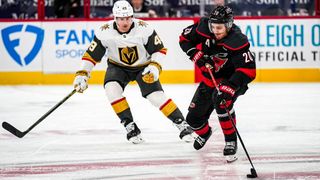 Sebastian Aho of the Carolina Hurricanes skates with the puck as Ivan Barbashev of the Vegas Golden Knights defends during an NHL game at Lenovo Center.