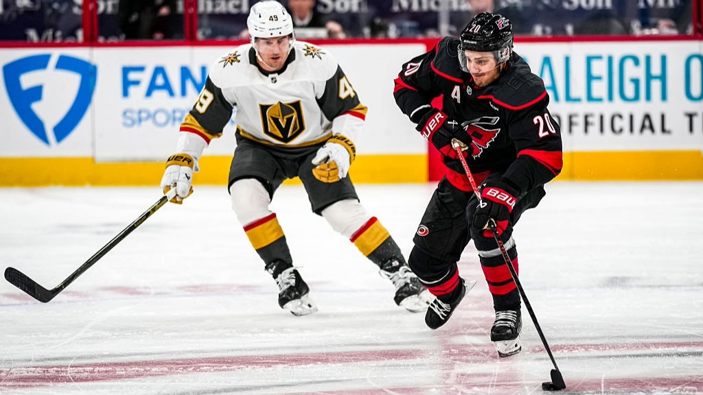 Sebastian Aho of the Carolina Hurricanes skates with the puck as Ivan Barbashev of the Vegas Golden Knights defends during an NHL game at Lenovo Center.