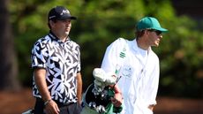 Patrick Reed walks with his caddie in a practice round prior to the 2024 Masters