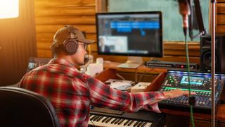 Man sits at a desk in his recording studio