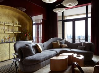 A living room with red lacquered walls and a gold bar