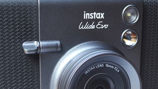 A black and gray Fujifilm Instax Wide Evo hybrid instant camera