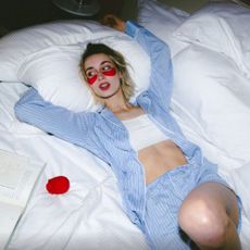 Woman in striped pjs next to Lovehoney rose vibrator