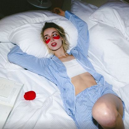 Woman in striped pjs next to Lovehoney rose vibrator