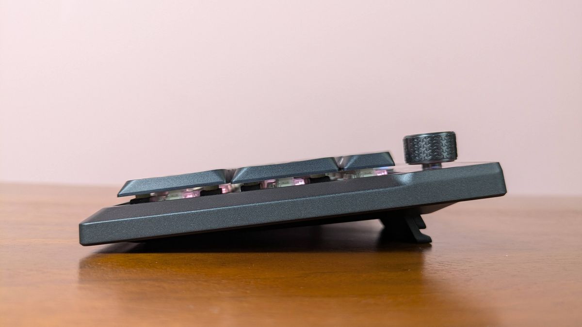 Side view of Corsair Vanguard Air 99 Wireless on brown desk with pink wall in background