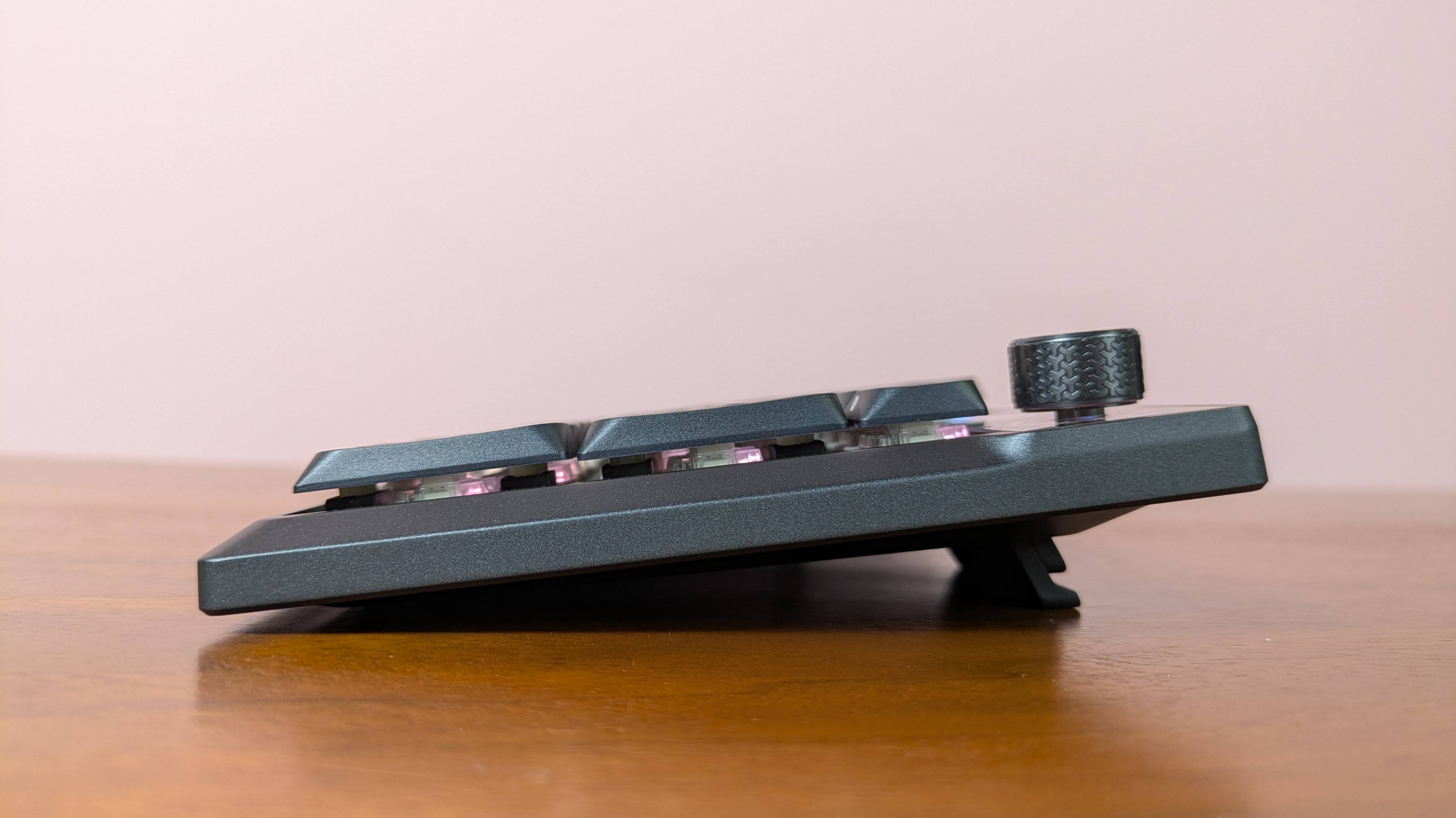 Side view of Corsair Vanguard Air 99 Wireless on brown desk with pink wall in background