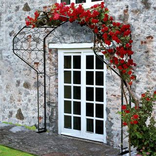 Metal frame around front door with roses