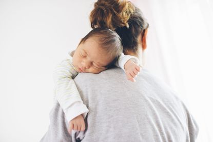 Woman holding baby over her shoulder