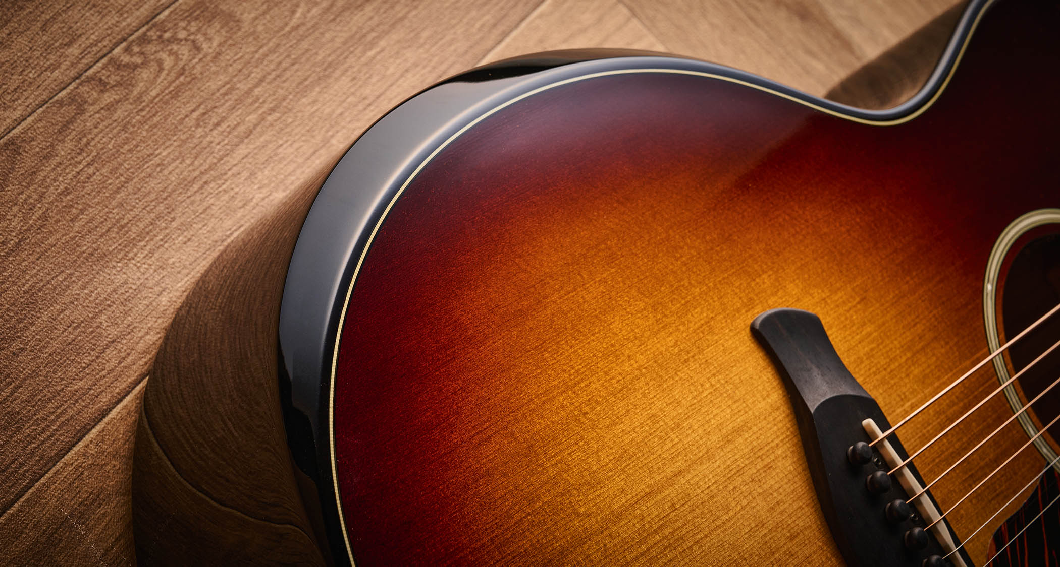 Taylor Builder’s Edition 514ce Kona Burst pictured against a wooden floor and patterned rug.
